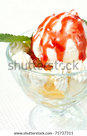 Ice-cream with strawberry jam, whipped cream and mint leaves
