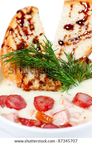 German soup with sausage, bacon and toast. Appetizing first course. Isolated on white