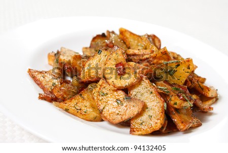 Potato wedges fried in oil on a plate. Golden and crispy