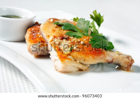Roasted chicken legs with garlic sauce. Nutritious white meat