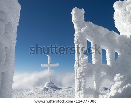 frozen cross in the mountains in winter