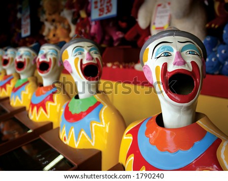 A row of clowns at an amusement park game.