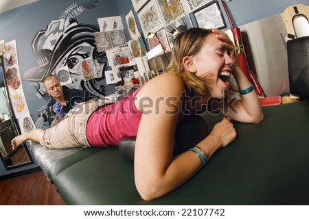 stock photo A tattoo artist applying his craft onto the lower leg of a 