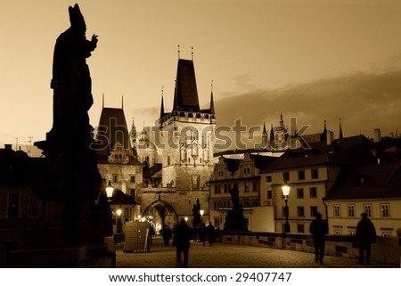 An evening view of the beautiful gothic architecture at the end of Charles Bridge.  Prague castle in the background.