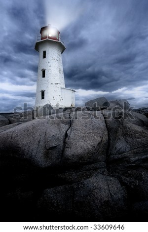 The lighthouse at Peggy\'s Cove in Nova Scotia Canada at dusk as a storm grows.