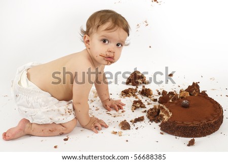 An adorable one year old girl enjoying her first birthday cake.