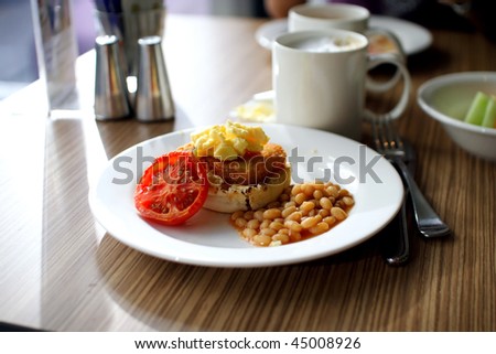 delicious breakfast with hash brown, scrambled egg, toast, baked tomato beans, tomato and coffee