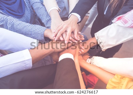 many handshake of young arab business people join hug team work out office . this hand of group corporate mix partnership  \
multiple ethnicity