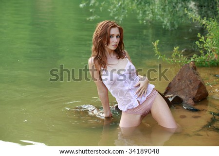 Girl with red hair in the water