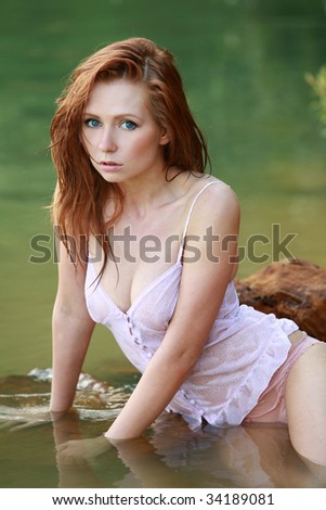 Girl with red hair in the water