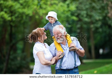 Little Boy Having Fun With His Grandparents In Park