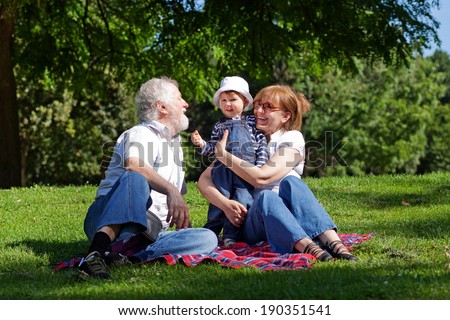 Little boy with his grandparents having fun in the park