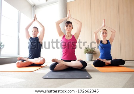Young people meditating in a yoga class Young people meditating in a yoga class