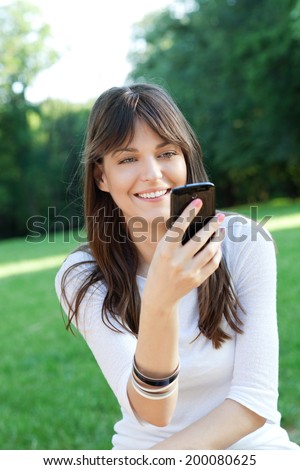Young beautiful woman using cell phone outdoor