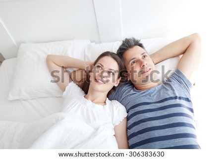 Young couple lying on bed, relaxing