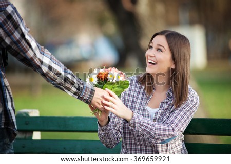 Young woman receiving a bunch of wild flowers on a date