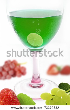 green alcohol cocktail with mix fruit on white background