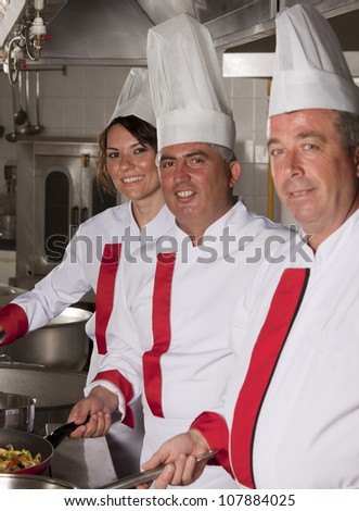 group of young beautiful professional chefs portrait in industrial kitchen