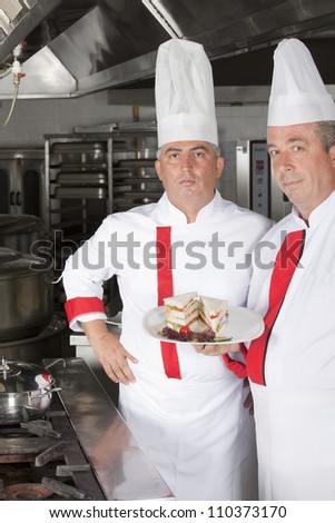 group of young professional chefs portrait in industrial kitchen