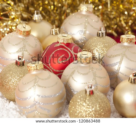 Red and gold Christmas baubles on background of with golden lights
