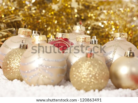 Red and gold Christmas baubles on background of with golden lights