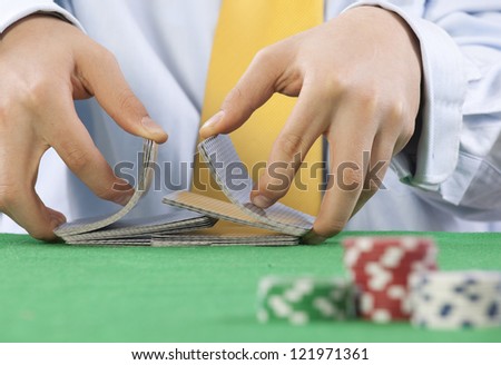 Two hands, shuffling a deck of cards of poker