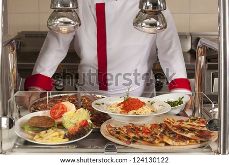 chef standing behind burger and pizza station