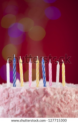 happy birthday cake shot on a red background with candles