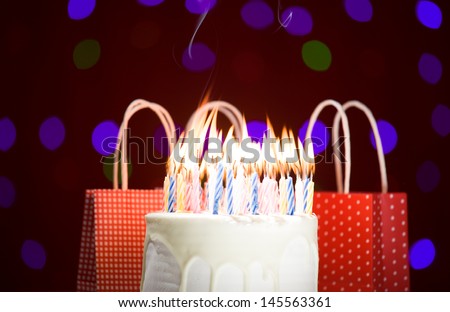 happy birthday cake shot on a red blurred background with candles