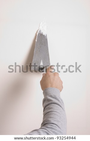 Putty Knife with Paste to Repair Wall Damage