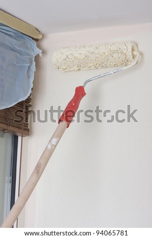 house painter using a paint roller, painting a wall in motion