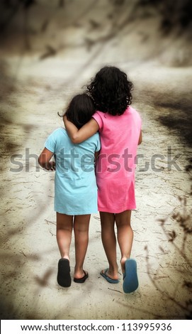 Two young girls in blue and pink dresses walking away with their backs turned