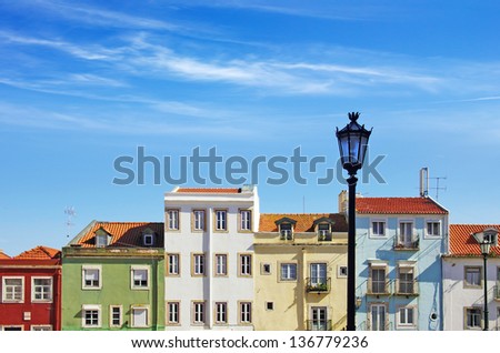 Picturesque Lisbon neighborhood with colorful block of houses under sunny blue sky