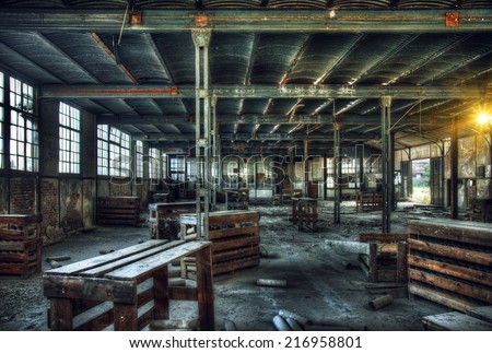 HDR - old abandoned factory interior with wooden tables and boxes