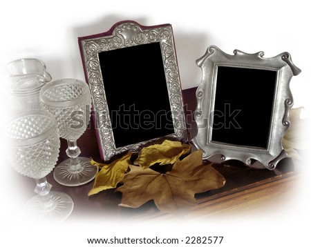 Two vintage silver photo frames and old glasses, surrounded with a white vignette.