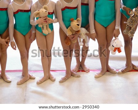 Photo of a team of girl gymnasts in a rhythmic-gymnastics event.