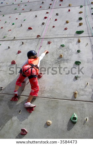 Youngster\'s effort in climbing a wall to reach the top.