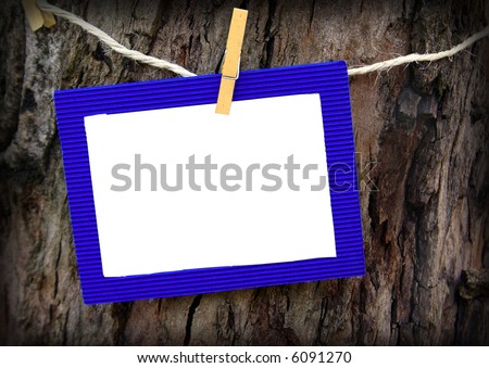 Close-up of a empty blue paper frame hanged in a rope with a wooden pin