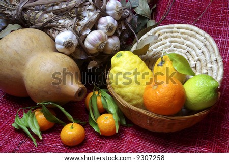 Arrangement with lemon, tangerine, garlic, laurel and a gourd.