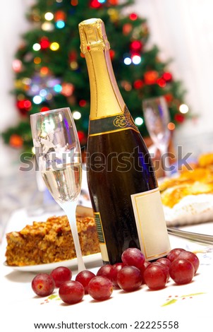 Fluted glass and champagne bottle in a Christmas celebrating table with food