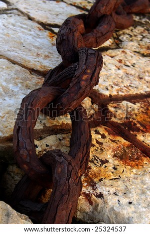 Old industrial chain links in cement block at the harbor