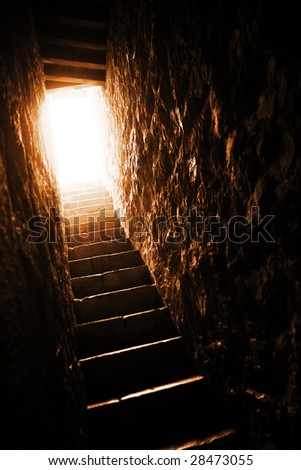 Tight stairway of a medieval castle that leads into the light