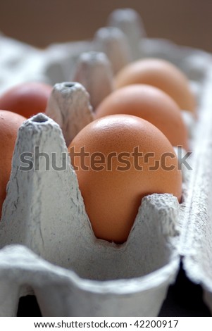 Close-up of five fresh eggs in a box made of recycled paper