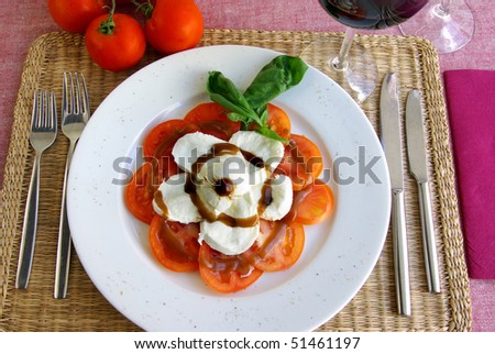 Table set with an Italian salad of tomato and mozzarella cheese
