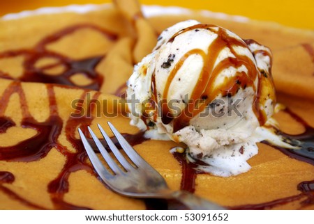 Delicious caramel ice cream over a crepe with chocolate topping