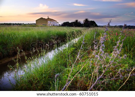 Beautiful countryside landscape with an old house ant sunset