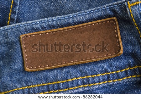 Close-up of old leather tag with copy space, sewed on blue jeans back