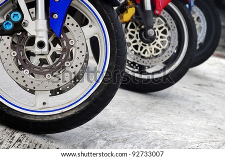 Row of three motorcycle wheels parked in a road