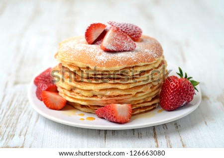 stack of freshly prepared traditional pancakes with strawberries