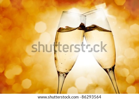 Two elegant champagne glasses on golden background